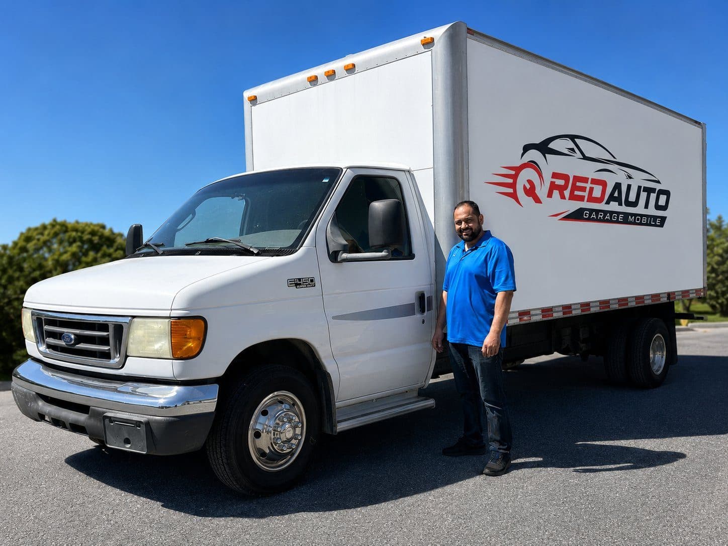 RedAuto mechanic beside the fully equipped mobile service truck